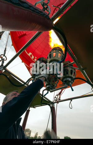 Pilot feuert die Brenner um Auftrieb während des Starts in einem Heißluftballon, Shropshire, UK Stockfoto