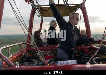 Piloten, die Lenkung von eines Heißluftballons mit Passagieren genießen die Aussicht, Shropshire, UK Stockfoto