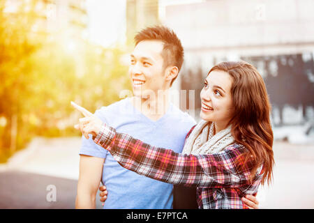 Romantische interracial junge Paare stehen zusammen zeigen außerhalb im Abendlicht mit absichtlichen Blendenfleck Stockfoto