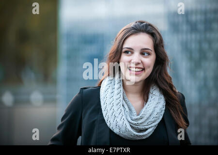 Ehrliche Portrait von junge Brünette Frau lächelnd und Blick auf Seite mit Textfreiraum Stockfoto