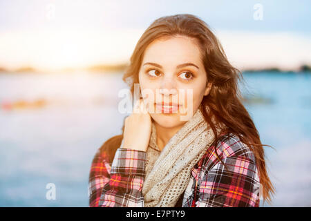 Ehrliche Portrait von junge Brünette Frau am Sonnenuntergang wegschauen mit Textfreiraum Stockfoto