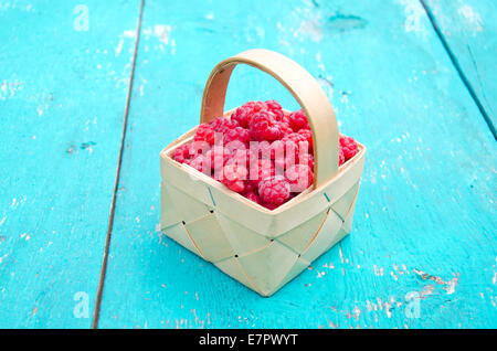frischen sommerlichen Himbeer Frucht in hölzernen kleinen Korb auf alten Gartentisch Stockfoto