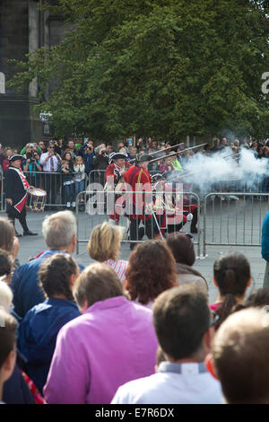 Eine Reenactment-Gesellschaft gekleidet als Red Coats marschieren vor Publikum auf der Royal Mile in Edinburgh. Stockfoto