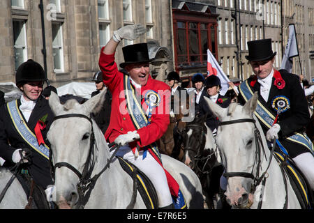 Ein Mann auf einem Pferd winken für Menschen in der Menge auf der Royal Mile in Edinburgh vor dem jährlichen Reiten der feierlichen Märschen. Stockfoto