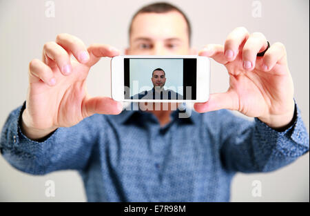 Glücklicher Mann nehmen Selfie. Smartphone im Fokus Stockfoto