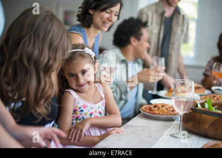 Ein Familientreffen für eine Mahlzeit. Erwachsene und Kinder an einem Tisch. Stockfoto