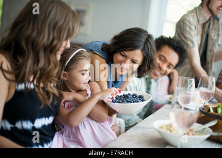 Ein Familientreffen für eine Mahlzeit. Erwachsene und Kinder an einem Tisch. Stockfoto