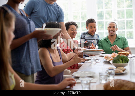 Ein Familientreffen, Männer, Frauen und Kinder um eine gemeinsame Mahlzeit Esstisch. Stockfoto