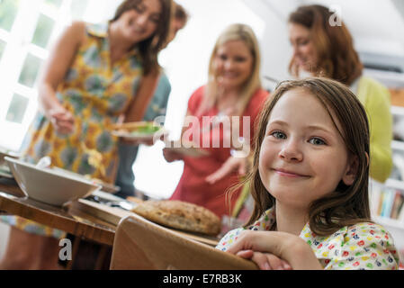 Ein Familientreffen für eine Mahlzeit. Erwachsene und Kinder an einem Tisch. Stockfoto