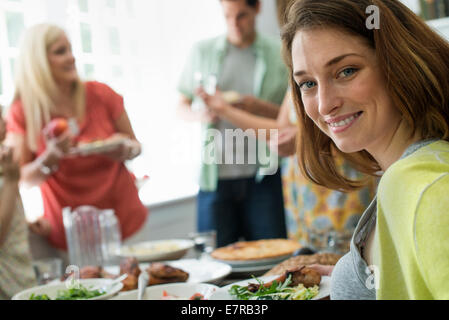 Ein Familientreffen für eine Mahlzeit. Erwachsene und Kinder an einem Tisch. Stockfoto