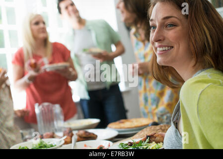 Ein Familientreffen für eine Mahlzeit. Erwachsene und Kinder an einem Tisch. Stockfoto