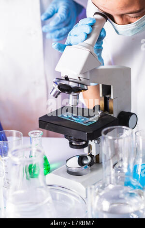Junge Wissenschaftler freuen sich auf das Mikroskop Okular im chemischen Labor Stockfoto