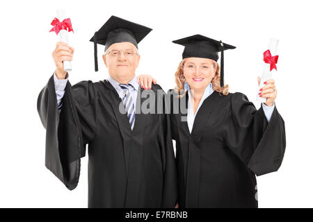 Älteres Paar feiert ihre Diplome isoliert auf weißem Hintergrund Stockfoto