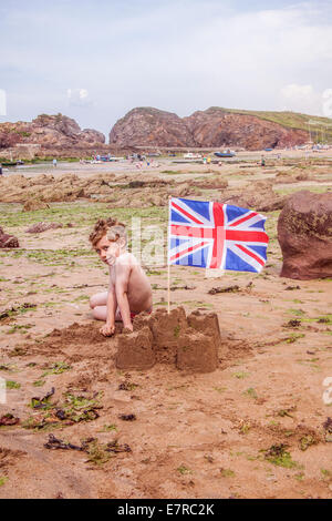 Fünf Jahre alten Jungen mit einer Sandburg, Hope Cove Beach, South Devon, England, Vereinigtes Königreich. Stockfoto