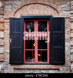 Retro-Fenster mit schwarzen Jalousie im Freien und Brich Stadtmauer Stockfoto