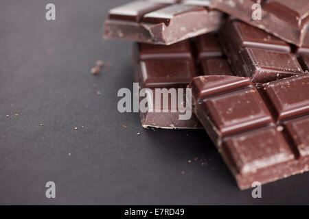 Stücke von Schokolade auf schwarzem Hintergrund. Close-up. Stockfoto