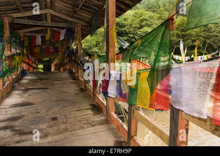 Ost Bhutan, Trashi Yangtse, Gebetsfahnen, die alte Holzbrücke über Dongdi Chu-Fluss entlang Stockfoto