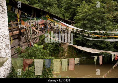 Ost Bhutan, Trashi Yangtse, alte Holzbrücke über Dongdi Chu-Fluss mit Gebetsfahnen geschmückt Stockfoto