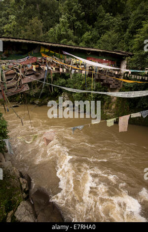 Ost Bhutan, Trashi Yangtse, alte Holzbrücke über Dongdi Chu-Fluss mit Gebetsfahnen geschmückt Stockfoto