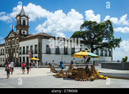 Brasilien, Salvador, Praça Da Se, ein Hersteller von Musikinstrumenten und Misericordia Kirche im Hintergrund Stockfoto