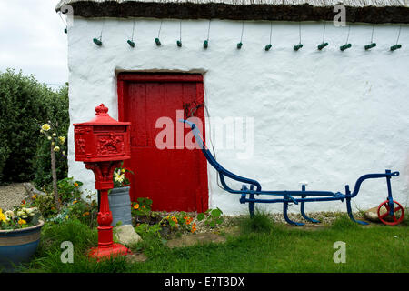 Viktorianischen roten Sockel Brief Briefkasten außerhalb einer traditionellen 19. Jahrhundert irische Stroh Dach Hütte, Malin Head, County Donegal, Stockfoto