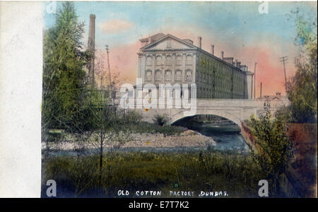 Dieses Foto zeigt eine in Betrieb befindliche Baumwollfabrik und zeigt die Maschinen, Arbeiter und den Umfang der Baumwollproduktion während der industriellen Ära des frühen 20. Jahrhunderts. Stockfoto