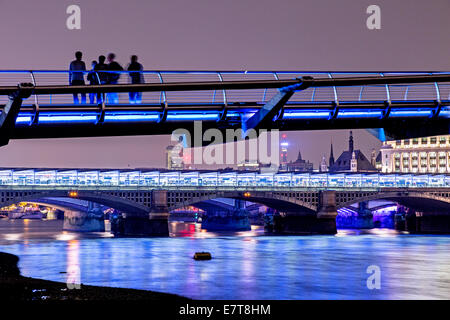 Menschen stehen auf der Millennium Bridge bei Nacht UK Stockfoto