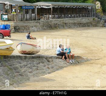 Menschen sitzen und entspannen in Newquay Hafen Cornwall England uk Stockfoto