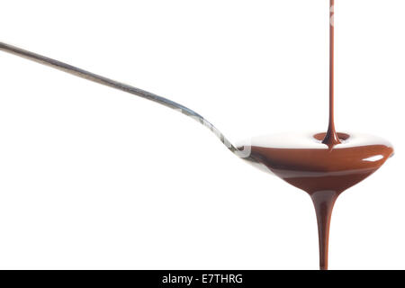 Schokolade in einem Löffel gegossen auf weißem Hintergrund Stockfoto