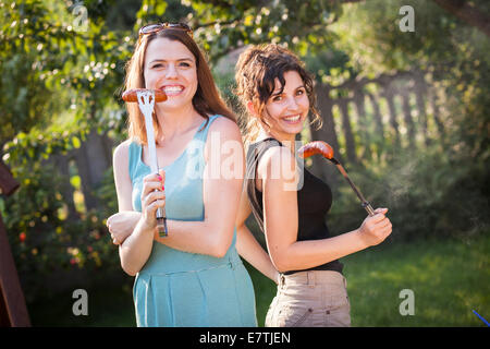 Zwei hübsche Mädchen, die Zubereitung von Essen auf grill Stockfoto