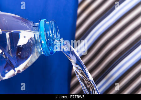 Wasser aus Kunststoff-Flasche von dem Geschäftsmann gießen. Stockfoto