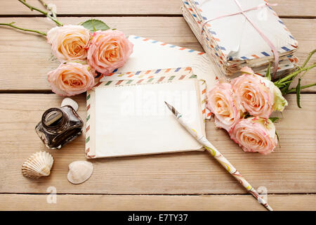 Vintage Buchstaben, Rosen und Tintenfass auf Holztisch. Ansicht von oben, Textfreiraum Stockfoto
