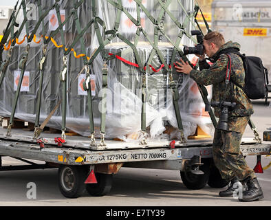 Schkeuditz, Deutschland. 24. September 2014. Ein Bundeswehr-Fotograf macht Fotos von Boxen mit Waffen und Munition, die warten auf einen Typ Douglas KC-10 Transportflugzeuge der niederländischen Luftwaffe am Flughafen Halle/Leipzig in Schkeuditz, Deutschland, 24. September 2014 werden. Diese Lieferung von Panzerfäusten, Gewehre und Munition markiert den Beginn der deutschen Waffenlieferungen für die Bekämpfung der Terrorgruppe islamischer Staat (IS) im Irak. Die Waffen sind für die kurdische Peshmerga Streitkräfte von der kurdischen Regionalregierung im Nordirak bestimmt. 10.000 kurdische Kämpfer wil Stockfoto