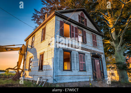 Die Reste eines 300 Jahre alten Hauses stehen bereit, um abgerissen zu werden, wenn die Sonne über East Falmouth, Massachusetts aufgeht- Stockfoto