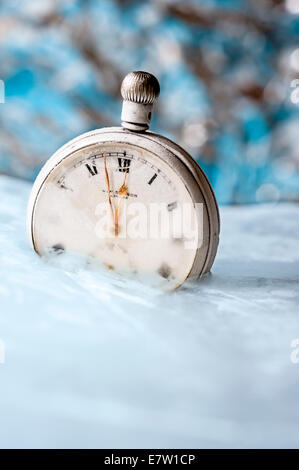 Alte Taschenuhr in Eis eingefroren. Stockfoto