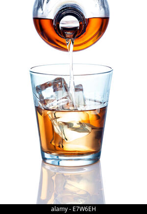 Eine Flasche Gießen einen Drink. Trinken könnte dunkler Rum, Whisky, Bourbon, Brandy oder andere ähnliche farbige Alkohol. Stockfoto