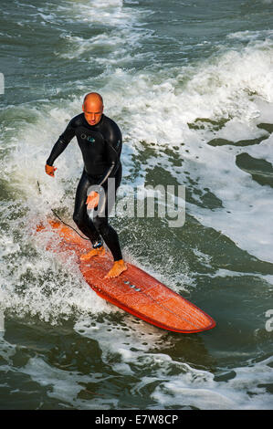 Mittleren Alters Surfer im Neoprenanzug auf einer Welle auf Surfbrett an der Nordsee Stockfoto