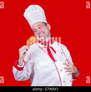 Koch in seiner Hand hält eine Hühnerkeule Stockfoto