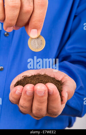 Geschäftsmann Hand mit Haufen von Boden und Münze für den Anbau von Finanzen. Stockfoto