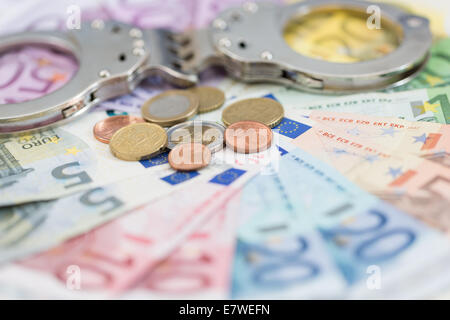 Polizeihandschellen und Euro-Geld Stockfoto