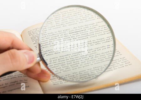 Hand halten klassisch Lupe und Lesebuch, isoliert auf weißem Hintergrund zu prüfen. Stockfoto