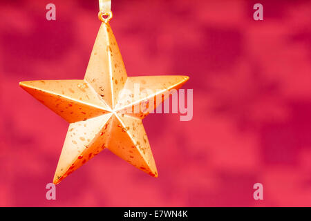 Eine sternförmige Christbaumkugel Kastanienbraun / roten Hintergrund. Als Hintergrund oder in Weihnachtskarten verwendet werden. Stockfoto