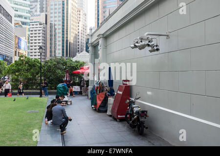 Die Menschen sitzen durch eine Bank von Überwachungskameras in das zentrale Geschäftsviertel von Singapur. Stockfoto