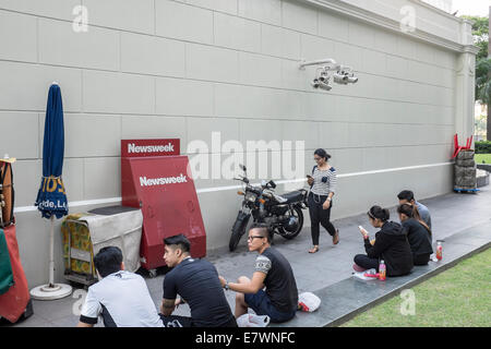 Die Menschen sitzen durch eine Bank von Überwachungskameras in das zentrale Geschäftsviertel von Singapur. Stockfoto
