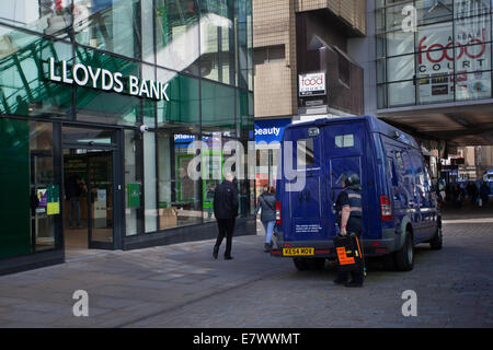 Woman G4S Employee Security Guard, die Lloyds Bank, Manchester Piccadilly, Großbritannien, anliefert oder von dieser einsammelt Stockfoto