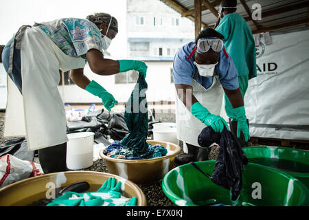 Gesundheit der Arbeitnehmer zu reinigen Krankenhaus Peelings und Schutzausrüstung in der neu eröffneten Insel Klinik für Ebola-Behandlung 22. September 2014 in Monrovia, Liberia. Die Anlage wurde eröffnet von der WHO und dem Gesundheitsministerium als Reaktion auf den Anstieg der Patienten benötigen eine Ebola-Behandlung. Stockfoto