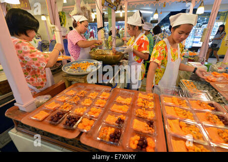 Bangkok, Thailand - 27. März 2014: Frauen machen Süßigkeiten auf einem Markt in Bangkok, Thailand. Stockfoto