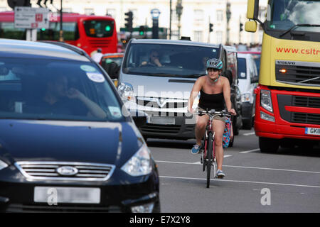 Eine weibliche Radfahrer unterwegs unter Verkehr in London Stockfoto