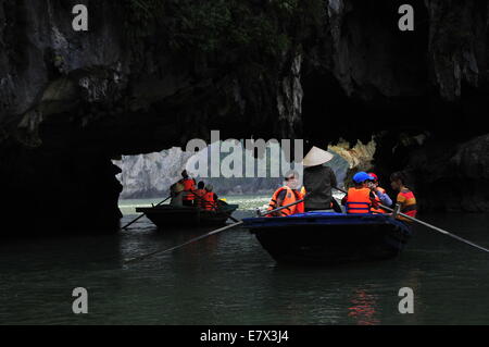 Ha Long Bucht, Vietnam. 24. Sep, 2014. --Boote segeln durch Bögen an der Unterseite der Inseln in Ha Long Bay, Nordvietnam, 24. September 2014. Ha Long Bay, im Golf von Tonkin, enthält einige 1.600 Inseln und Inselchen, bilden eine spektakuläre Seenlandschaft von Kalksteinsäulen. Aufgrund ihrer schroffen Natur sind die meisten Inseln unbewohnt und unberührt von menschlicher Anwesenheit. Herausragende landschaftliche Schönheit des Aufstellungsortes wird durch seine große biologische Interesse ergänzt. Es war im Jahr 1994 eingeschriebenen im UNESCO Weltnaturerbe-Liste. (Xinhua/Zhang Jianhua) Stockfoto