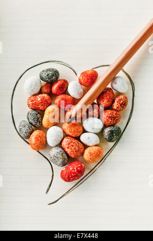 Herz aus Stein durchbohrt von Bleistift, Liebe überwindet das härteste Herz Stockfoto